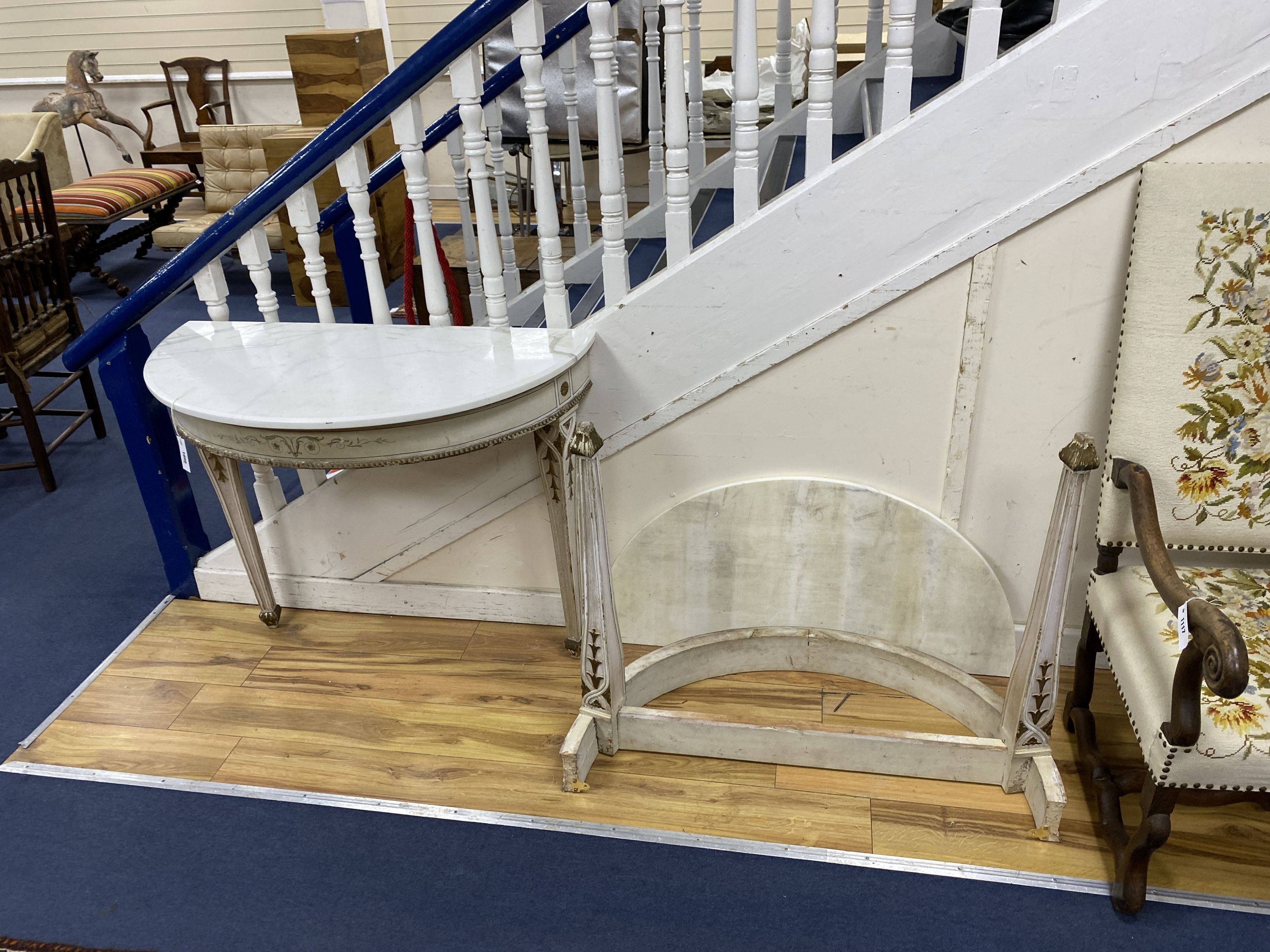 A pair of French marble topped demi lune console tables, with later veined white marble tops and parcel gilt painted underframes, width 100cm depth 47cm height 79cm